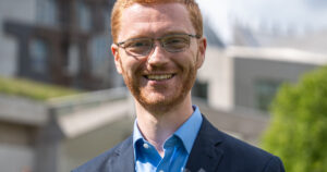 Ross Greer MSP in front of the Scottish Parliament (credit: Scottish Greens)